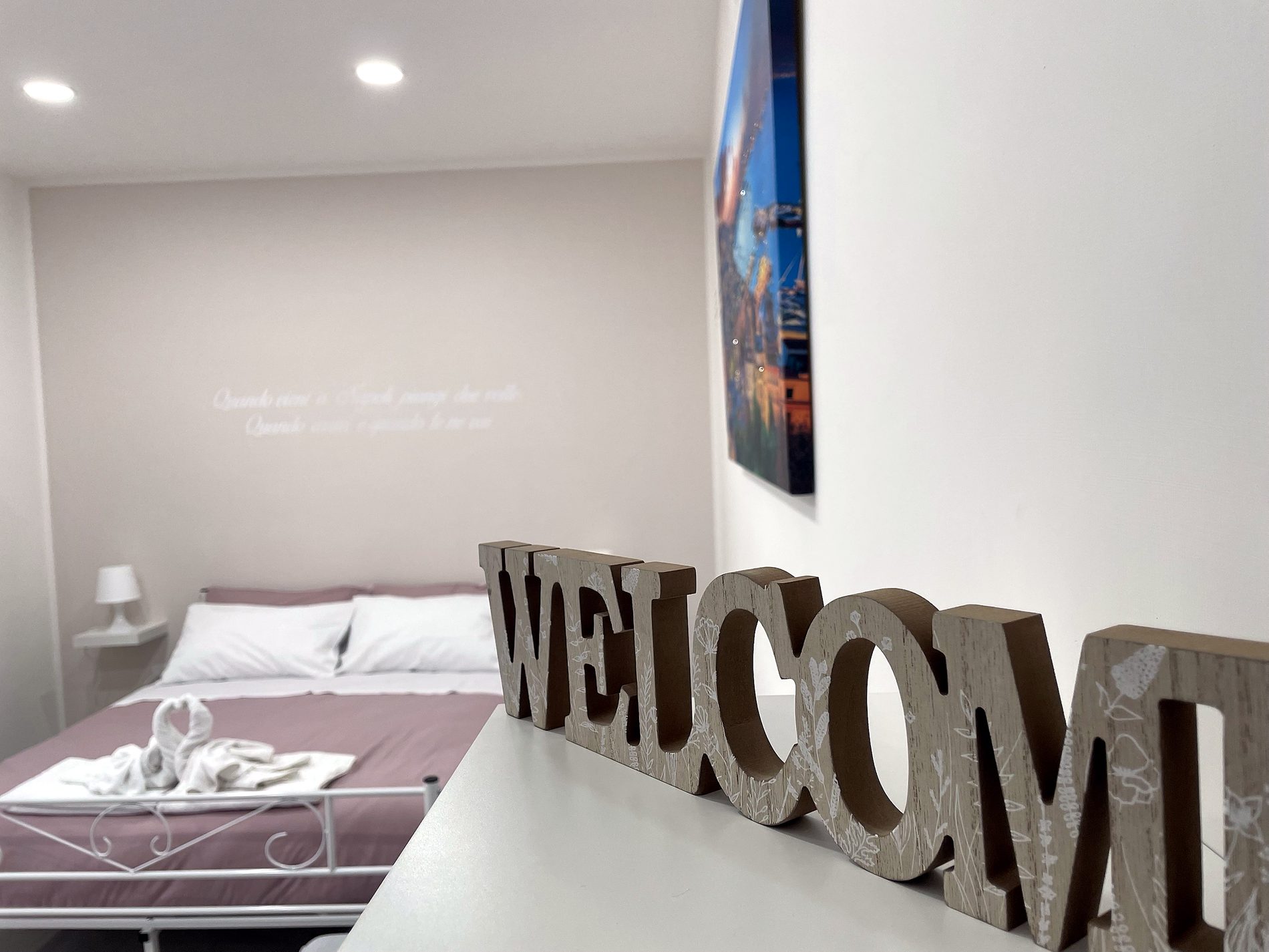 Camera con letto matrimoniale e scritta Welcome, Una Notte a Napoli, camera con bagno privato vicino all'aeroporto di Napoli