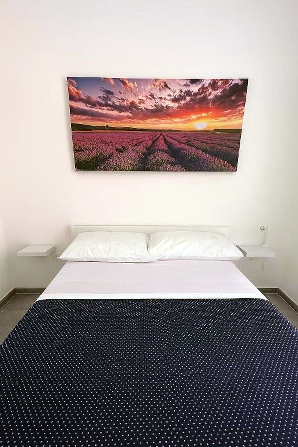Testata del letto con quadro di lavanda al tramonto, camera Cuntrora, GGRoom San Giovanni