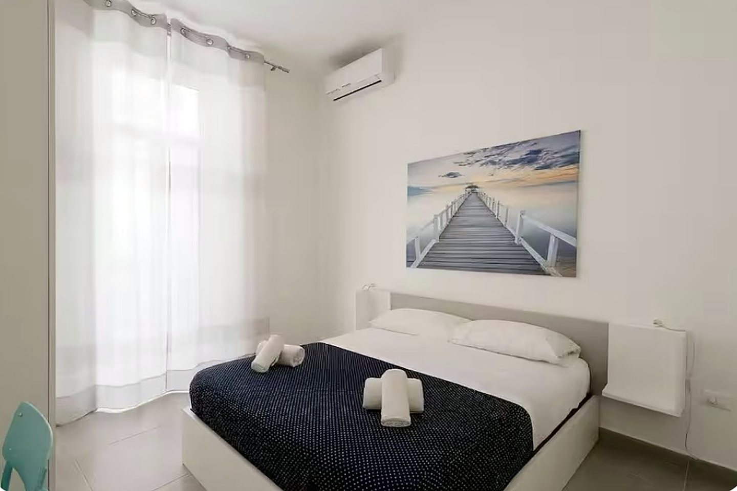 Camera O Sole Mio con letto matrimoniale, quadro del molo e tende bianche, GGRoom San Giovanni, centro storico di Napoli
