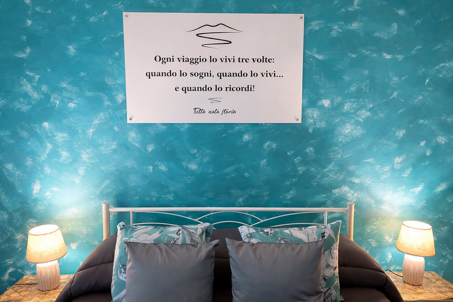 Testata del letto con la frase di viaggio Tutta 'nata storia e lampade, appartamento a Napoli